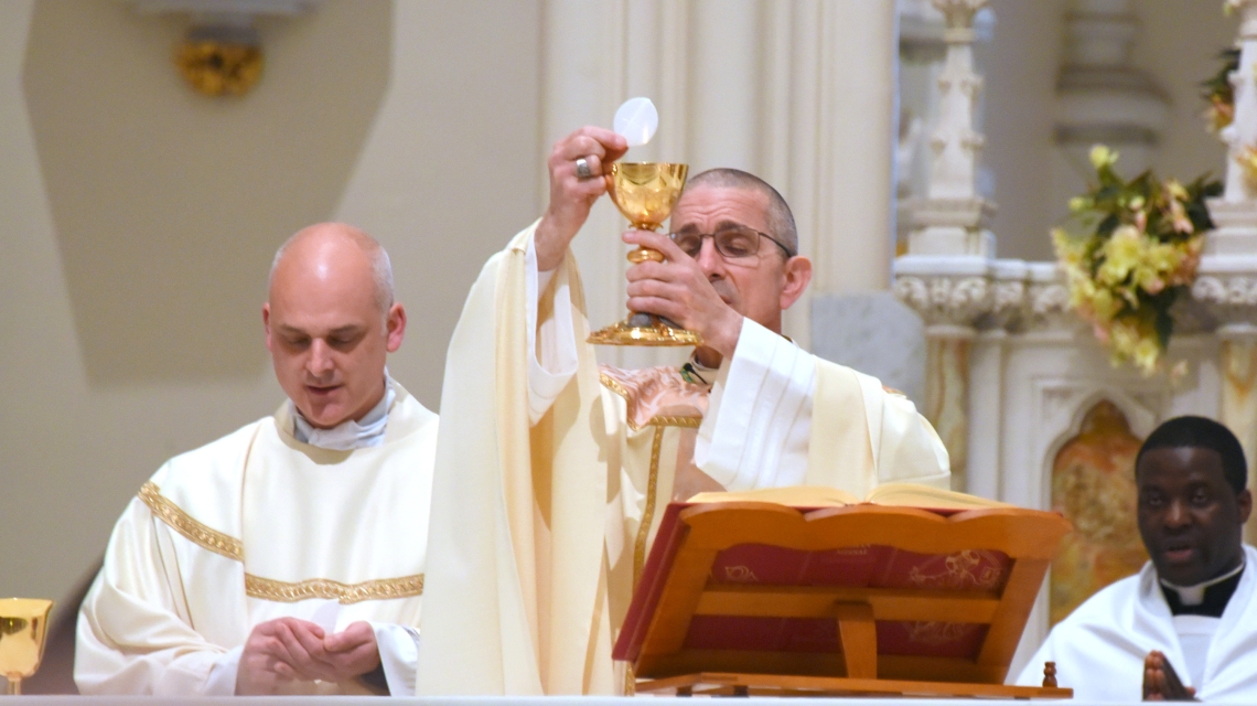 Bishop James Ruggieri holds up the host during the Liturgy of the Eucharist.