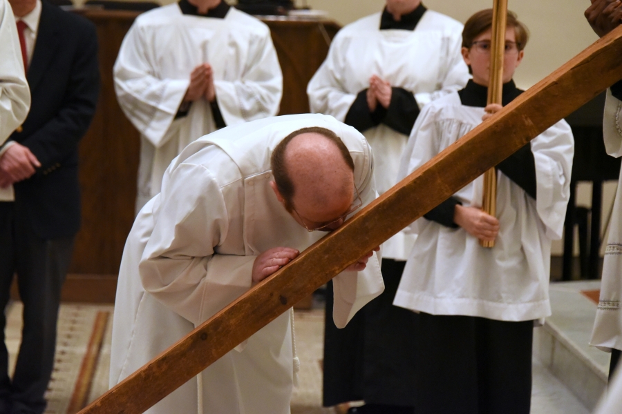Father Kevin Upham kisses the cross.