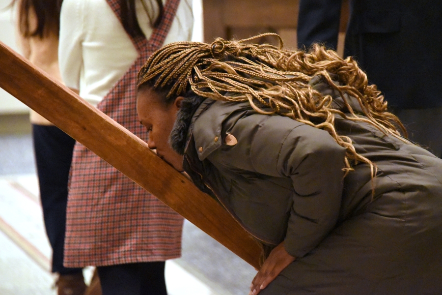 A female parishioner kisses the cross.