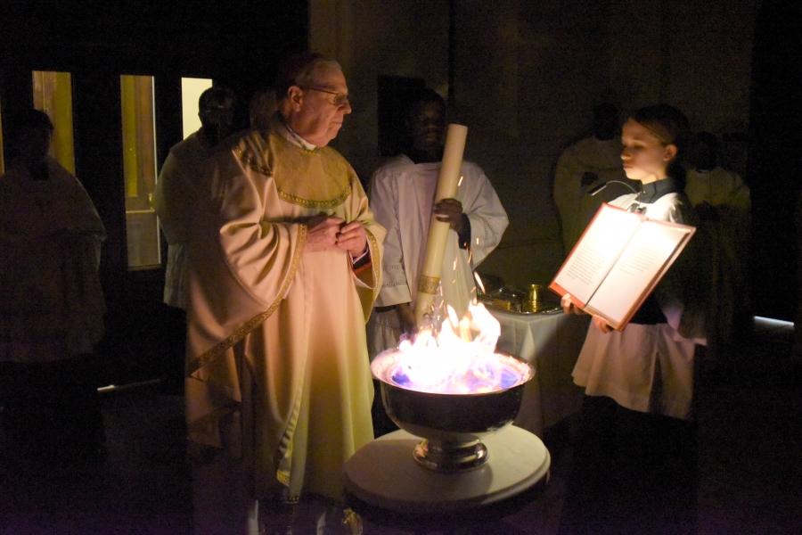 The bishop touches the nails on the candle.