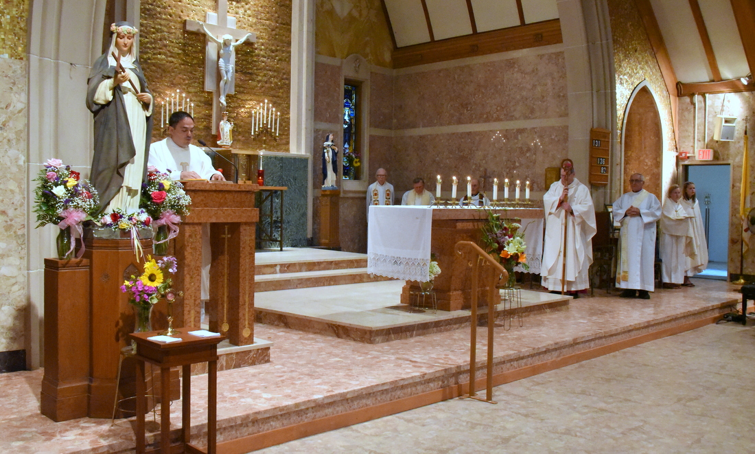 Father Paul Dumais delivers the Gospel at St. Rose of Lima Church's anniversary Mass.