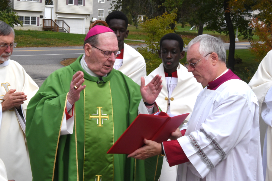 Bishop Deeley offers a blessing before a statue of St. Anne.