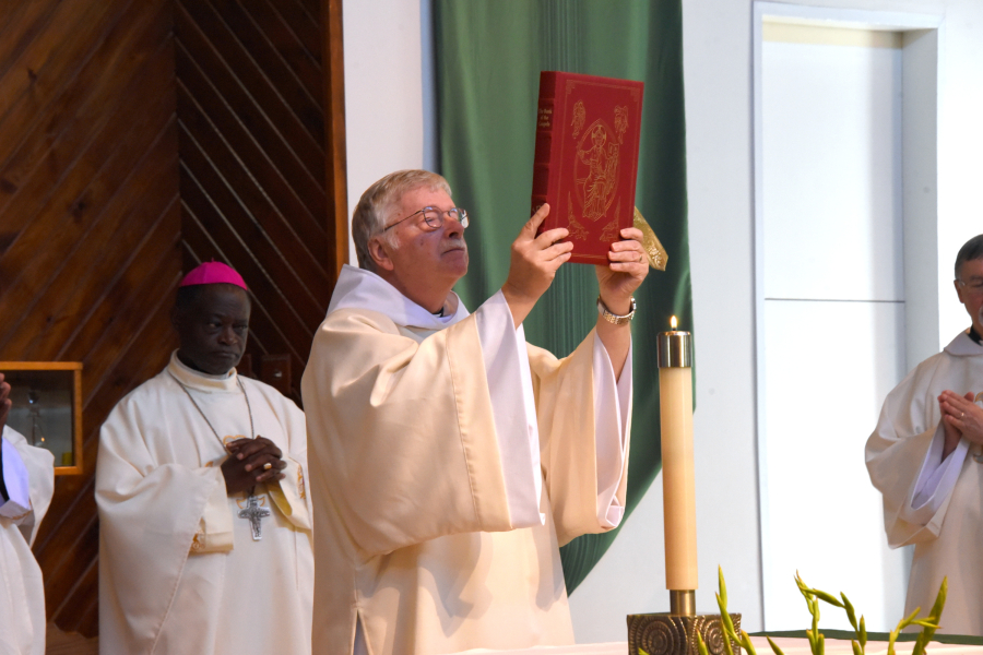 Deacon Larry Guertin holds up the Book of the Gospels