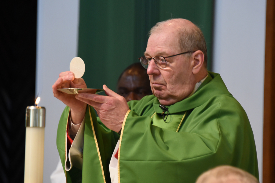 Bishop Robert Deeley holds up the Eucharist.