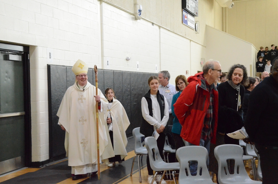 The bishop and altar servers process out of the gym