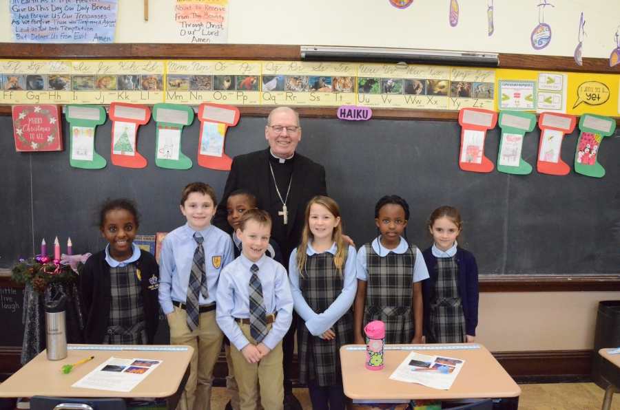 Seven students pose with the bishop