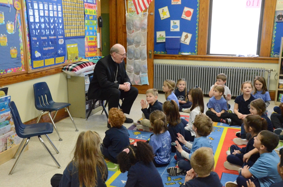 The bishop speaking to a group of seated students.