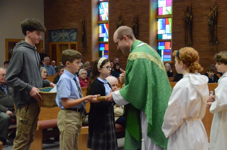 Priests receives gifts at Mass