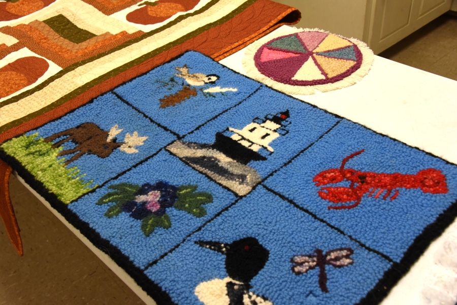 Rug with images from Maine including a lobster and a loon