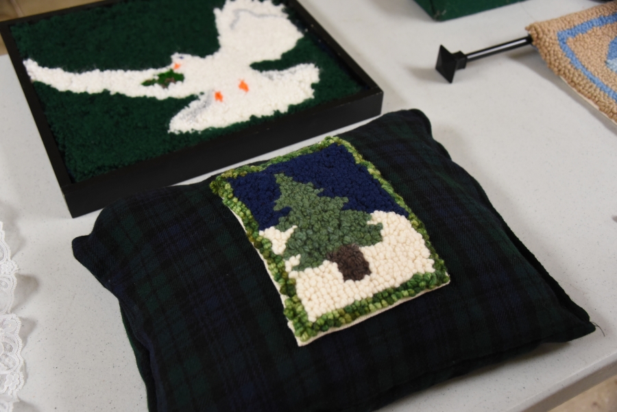 A pillow with a pine tree and a pillow with a dove