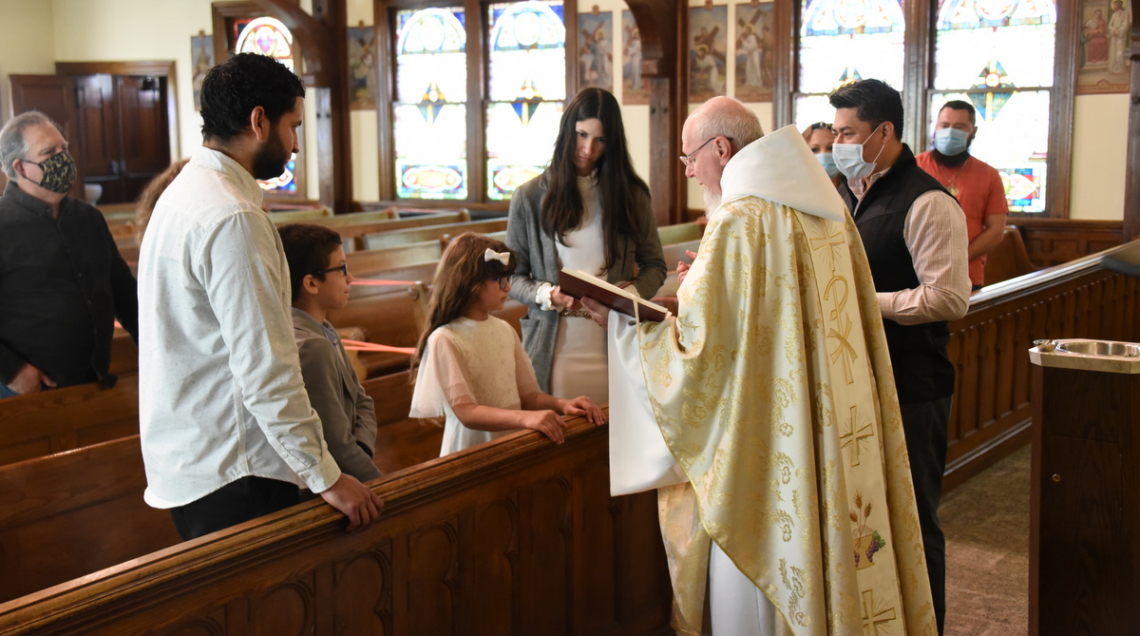 Father Sevigny baptizes 8-year-old Sylkia.