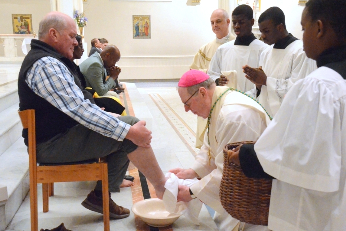 Bishop Deeley washes the feet of a man.